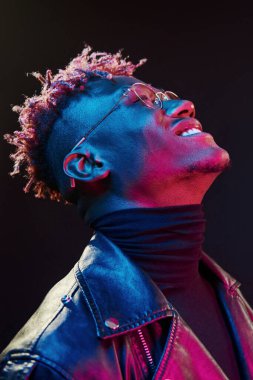 Gözlüklü. Fütürist neon ışıkları. Stüdyodaki Afrikalı Amerikalı genç adam..