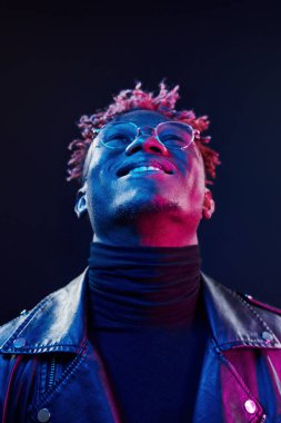 Gözlüklü. Fütürist neon ışıkları. Stüdyodaki Afrikalı Amerikalı genç adam..