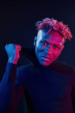 Fütürist neon ışıkları. Stüdyodaki Afrikalı Amerikalı genç adam..