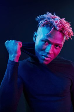 Fütürist neon ışıkları. Stüdyodaki Afrikalı Amerikalı genç adam..