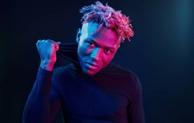 Fütürist neon ışıkları. Stüdyodaki Afrikalı Amerikalı genç adam..