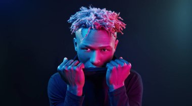 Fütürist neon ışıkları. Stüdyodaki Afrikalı Amerikalı genç adam..