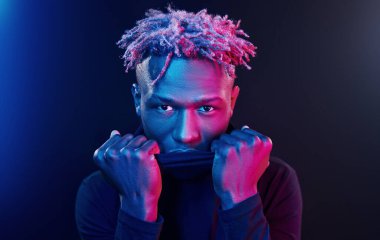 Fütürist neon ışıkları. Stüdyodaki Afrikalı Amerikalı genç adam..