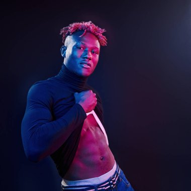 Fütürist neon ışıkları. Stüdyodaki Afrikalı Amerikalı genç adam..
