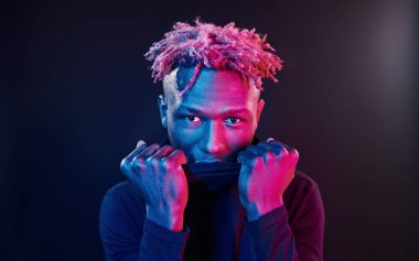 Fütürist neon ışıkları. Stüdyodaki Afrikalı Amerikalı genç adam..