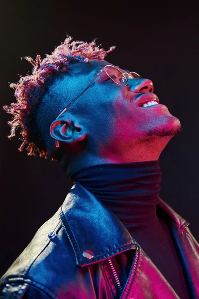 Gözlüklü. Fütürist neon ışıkları. Stüdyodaki Afrikalı Amerikalı genç adam..