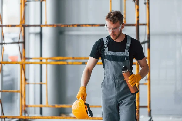 Man Grey Uniform Construction Takes Break Indoors Modern Big Office —  Fotos de Stock