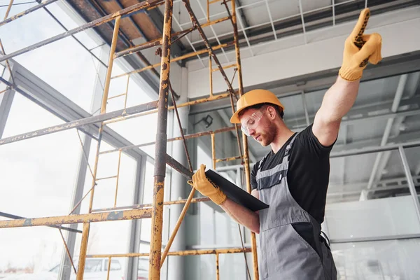 Ingenjör Grå Uniform Med Anteckningsblock Händerna Arbetar Inomhus Moderna Stora — Stockfoto