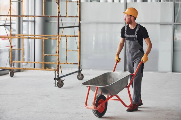Walks Wheelbarrows Man Grey Uniform Works Indoors Modern Big Office — Zdjęcie stockowe
