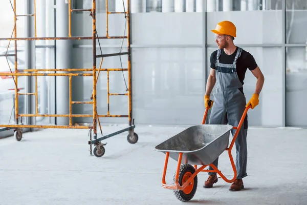 Går Med Skottkärror Man Grå Uniform Arbetar Inomhus Moderna Stora — Stockfoto