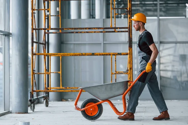 Walks Wheelbarrows Man Grey Uniform Works Indoors Modern Big Office — Stockfoto