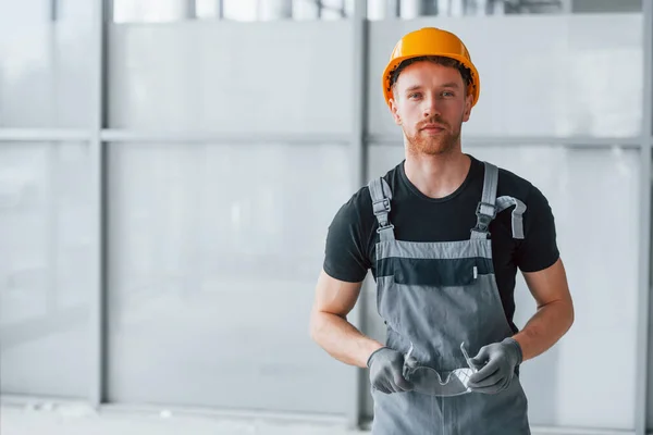 Portrait Man Grey Uniform Orange Hard Hat Standing Indoors Modern — 스톡 사진