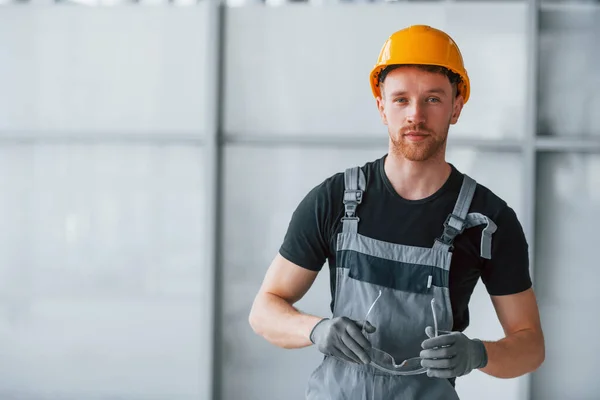 Portrait Man Grey Uniform Orange Hard Hat Standing Indoors Modern — Stockfoto