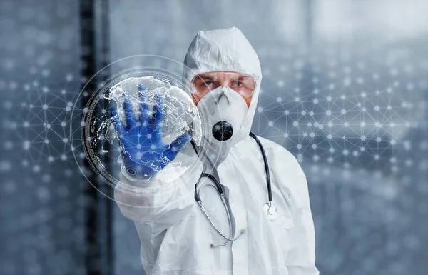 Dijital dünya haritası. Laboratuvar önlüklü, koruyucu gözlüklü ve maskeli bir erkek doktor içeride bekliyor..