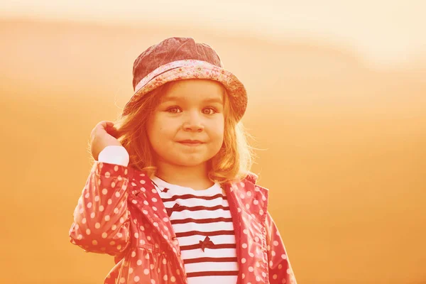 Portret Uroczej Dziewczynki Która Stoi Zewnątrz Oświetlony Pomarańczowym Słońcem — Zdjęcie stockowe