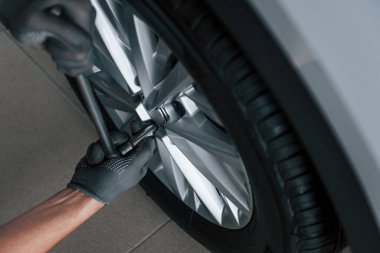 Close up view of man that changing tire of automobile. Conception of car service.