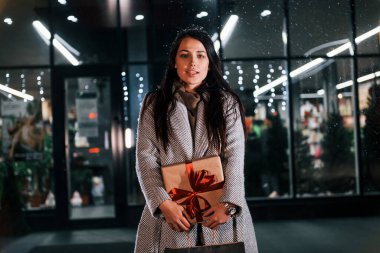 Şu anda ellerimizde. Neşeli kadın Noel tatilinde dışarıda. Yeni yıl kavramı.