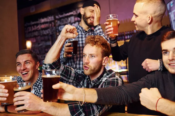 Futbol taraftarları zaferi kutluyor. Bir grup insan hafta sonları barda eğleniyor..