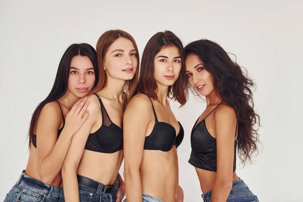 Fyra Unga Kvinnor Underkläder Tillsammans Inomhus Vit Bakgrund — Stockfoto