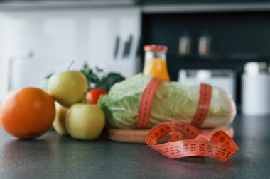 Mutfaktaki masada duran vejetaryen yemeğini yakından izle. Şerit, elma, portakal, meyve suyu..