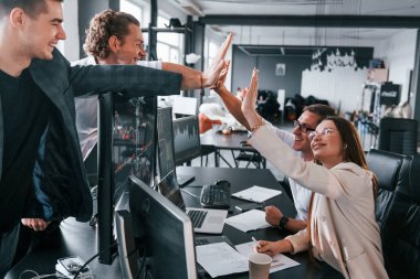 Çak bir beşlik. Borsacılardan oluşan bir ekip modern ofiste birçok ekran ekranı ile çalışır..