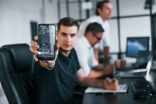 Muž Zobrazuje Informace Které Jsou Displeji Telefonu Tým Makléřů Pracuje — Stock fotografie
