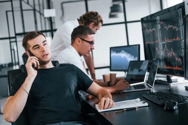 Ten Chlap Mluví Telefonu Tým Makléřů Pracuje Moderní Kanceláři Mnoha — Stock fotografie