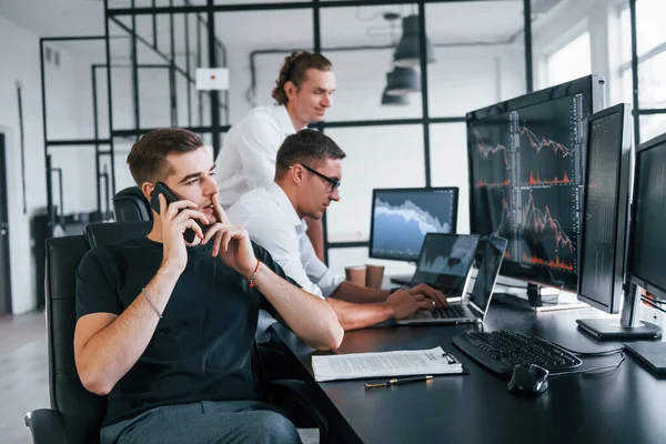 Ten Chlap Mluví Telefonu Tým Makléřů Pracuje Moderní Kanceláři Mnoha — Stock fotografie