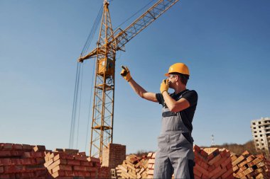 Construction worker in uniform and safety equipment have job on building.