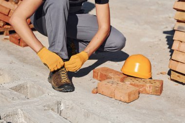 Üniformalı inşaat işçilerinin yakın görüntüsü ve güvenlik ekipmanları işe hazırlanıyor..