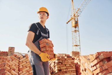 Installing brick wall. Construction worker in uniform and safety equipment have job on building.