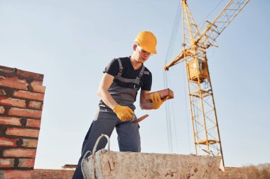 Construction worker in uniform and safety equipment have job on building.