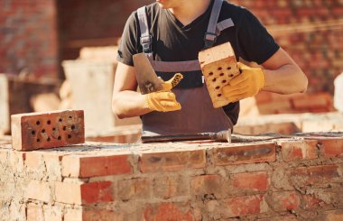 Construction worker in uniform and safety equipment have job on building.
