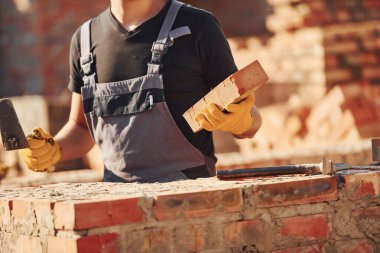 Construction worker in uniform and safety equipment have job on building.