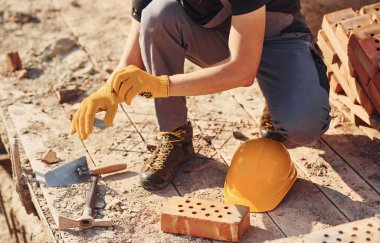 Close up view of construction worker in uniform and safety equipment preparing for the job.