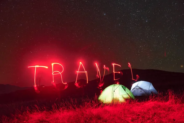 Palavra Viagem Néon Vermelho Duas Tendas Iluminadas Abaixo Estrelas Montanhas — Fotografia de Stock