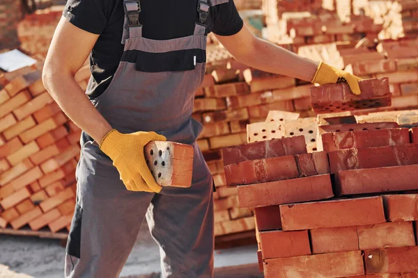 Construction worker in uniform and safety equipment have job on building.