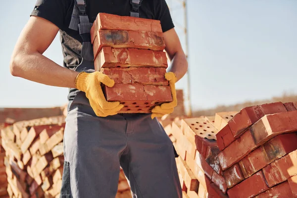 Installing brick wall. Construction worker in uniform and safety equipment have job on building.