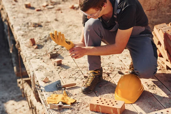 Close up view of construction worker in uniform and safety equipment preparing for the job.