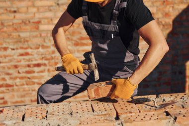 Construction worker in uniform and safety equipment have job on building.