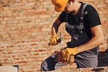 Construction worker in uniform and safety equipment have job on building.