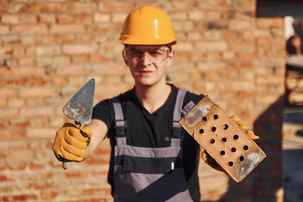 Portrait Construction Worker Uniform Safety Equipment Standing Building Holding Brick — Stockfoto