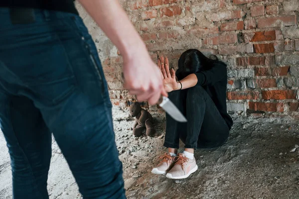 Violent Man Standing Knife Hand Threatens Girl Sits Floor Abandoned —  Fotos de Stock