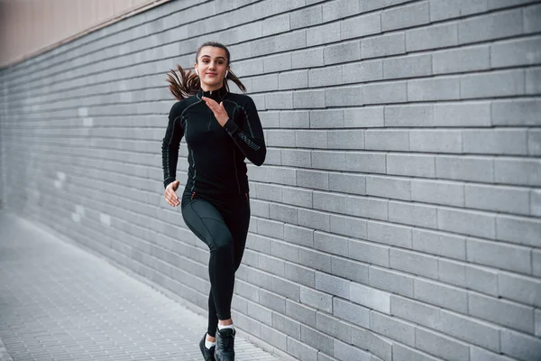 Junges Sportliches Mädchen Schwarzer Sportbekleidung Läuft Freien Nahe Der Grauen — Stockfoto