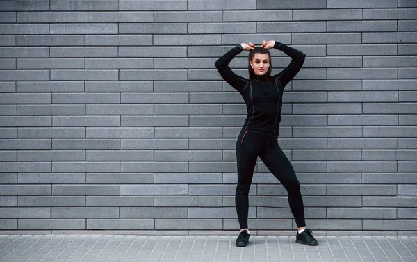 Young Sportive Girl Black Sportswear Standing Outdoors Gray Wall — стоковое фото