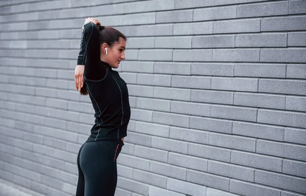Young Sportive Girl Black Sportswear Standing Outdoors Gray Wall — Stockfoto