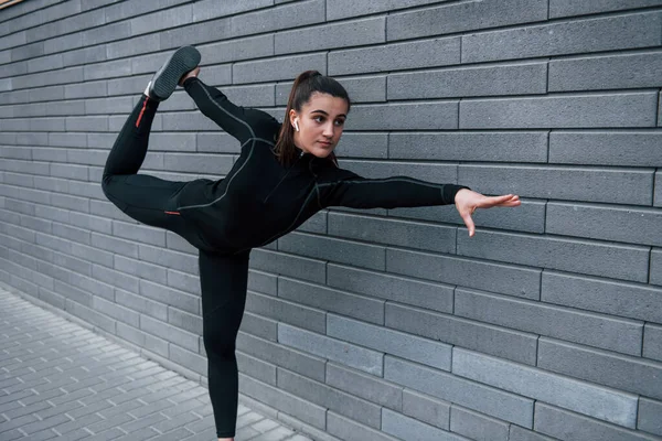 Young Sportive Girl Black Sportswear Outdoors Doing Yoga Exercises Gray —  Fotos de Stock