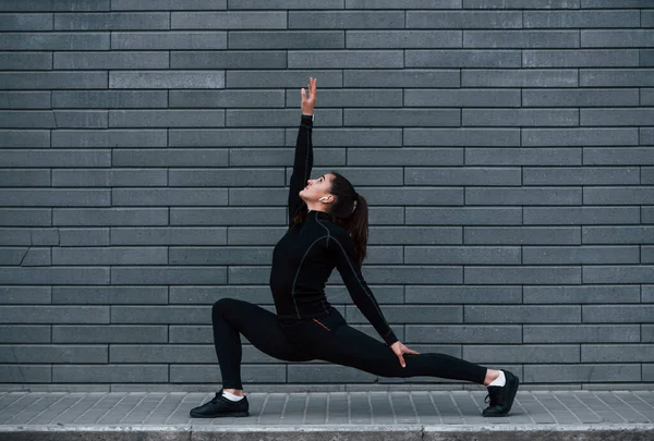 Young Sportive Girl Black Sportswear Outdoors Doing Yoga Exercises Gray — Stock fotografie