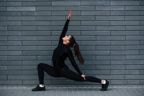 Young Sportive Girl Black Sportswear Outdoors Doing Yoga Exercises Gray — Stok fotoğraf