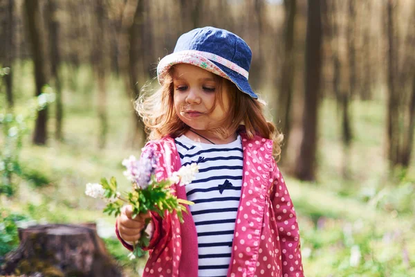 幸せな女の子で青の帽子持っています歩くで春の森の日 — ストック写真